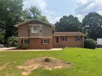 Charming two-story home featuring brick and wood facade with a well-maintained lawn and mature trees at 2206 Rhett Ct, Lawrenceville, GA 30044