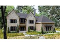 Stunning two-story home with a beautiful brick facade, dark shutters, and mature landscaping at 5743 Brendlynn Dr, Suwanee, GA 30024