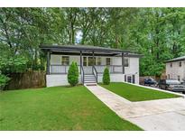 Charming renovated home with a covered front porch, lush lawn, and painted brick facade at 2266 Kennedy Nw Ct, Atlanta, GA 30318