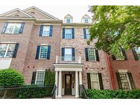 Elegant brick townhouse with dark shutters, stately columns, and well-maintained landscaping at 4810 Ivy Ridge Se Dr # 303, Atlanta, GA 30339
