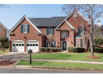 Charming brick home featuring a manicured lawn, attached garage, and complemented by tasteful landscaping at 1107 Carroll Ct, Norcross, GA 30071