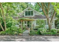 Charming home featuring a lush, landscaped front yard and inviting entrance with pergola at 4621 Lakeshore Dr, Pine Lake, GA 30072