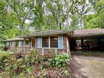 Charming single story brick house with carport and front porch nestled among mature trees at 1333 Council Bluff Ne Dr, Atlanta, GA 30345