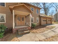 Charming brown two-story home with a covered porch and attached garage at 4354 Revere Cir, Marietta, GA 30062