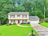 Charming two-story home with red shutters, a well-manicured lawn, and an attached two-car garage at 3605 Hickory Se Cir, Smyrna, GA 30080