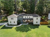 Inviting two-story home featuring a modern gray and white exterior, a manicured lawn, and mature trees at 3899 Carlton Dr, Chamblee, GA 30341