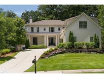 Charming two-story home boasts a landscaped yard and long driveway at 633 Channing Nw Dr, Atlanta, GA 30318