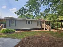 Charming single-story home features a covered porch, landscaped yard, and a convenient carport at 400 Old Stagecoach Rd, Carrollton, GA 30116