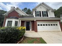 Charming two-story home with brick accents, a two-car garage, and a manicured front yard at 312 Yarbrough Ct, Dacula, GA 30019