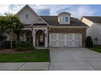 Charming home features a stone and brick facade, two-car garage, and a welcoming front porch at 513 Forest Ln, Canton, GA 30114