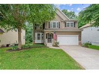 Charming two-story home featuring a well-manicured lawn, a two-car garage, and beautiful landscaping at 950 Mill Creek Ave, Canton, GA 30115