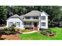 Charming two-story home with a landscaped front yard, a welcoming porch, and a symmetrical design at 9585 Fenbrook Ct, Johns Creek, GA 30022