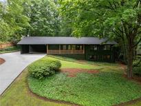 Charming single-story home with green siding, mature trees, and a covered portico at 2356 Sherbrooke Ne Dr, Atlanta, GA 30345