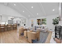 Bright, open-concept living room with vaulted ceilings and modern furniture flowing into the kitchen and dining areas at 2356 Sherbrooke Ne Dr, Atlanta, GA 30345