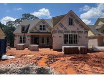 New construction home featuring a house wrap and brick accents with visible window frames, awaiting final touches at 2759 S Waterworks Rd, Buford, GA 30518