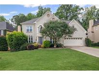 Charming two-story home with well-manicured lawn and mature landscaping, with an attached two car garage at 640 Windwalk Dr, Roswell, GA 30076