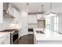 Modern kitchen features white cabinets, stainless steel appliances, and a large island with quartz countertop at 348 Olmstead Way # 30, Alpharetta, GA 30022