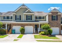 Inviting townhouse with a well-manicured lawn, attached garages and front porch at 442 Colonial Walk, Woodstock, GA 30189