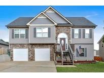 Charming two-story home featuring a two-car garage, stone accents, and a well-maintained front lawn at 218 Depot Ln, Dallas, GA 30157