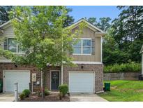 Charming two-story townhouse with brick facade, attached garage, and well-manicured landscaping at 3271 Pennington Dr, Stonecrest, GA 30038