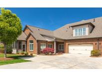 Lovely brick home featuring an attached two-car garage, manicured lawn, and mature trees on a sunny day at 328 Brookhaven Walk, Johns Creek, GA 30097