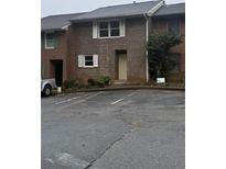 Townhouse featuring a brick facade, a front door and a parking lot at 4485 Golf Vista Cir, Decatur, GA 30035