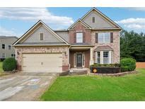 Charming two-story home featuring stone and brick accents, a two-car garage, and a well-manicured lawn at 1610 Kenilworth Se Ln, Conyers, GA 30013