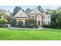 Beautiful two-story brick home with manicured lawn and landscaping, offering classic curb appeal at 3741 Cape York Trce, Alpharetta, GA 30022
