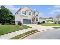 Charming two-story home with a painted brick facade, blue garage door, manicured lawn and inviting entryway at 610 Brickstone Ct, Covington, GA 30016
