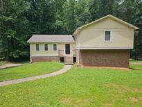 Inviting two-story home with a well-manicured lawn and pathway leading to the front entrance at 636 Raven Springs Trl, Stone Mountain, GA 30087
