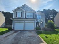 Charming two-story home featuring a two-car garage, well-manicured lawn, and inviting front entrance at 2527 Plymouth Way, Conyers, GA 30013