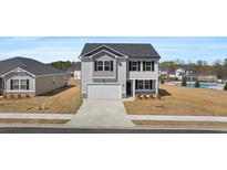 Charming two-story home boasts a manicured lawn, attached two-car garage, and classic architectural details at 8593 Secretariat Drive, Lithonia, GA 30058