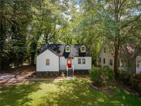 Charming renovated home with a bright red front door and beautifully landscaped front yard at 1956 Washington Rd, Atlanta, GA 30344