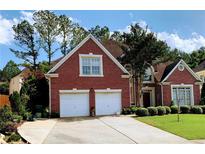 Charming two-story brick home featuring a well-manicured lawn and a two-car garage at 5018 Wickford Dr, Peachtree Corners, GA 30096