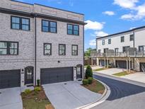 A modern townhouse showcasing a brick exterior, well-maintained landscaping, and private garage at 3382 Monarch Ave, Duluth, GA 30096