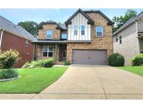 Charming two-story brick home with a well-manicured lawn and a two-car garage at 827 Autry Oak Ct, Johns Creek, GA 30022