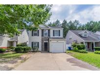Charming two-story home featuring a well-manicured lawn, and a one car garage at 3458 Carriage Chase Rd, Atlanta, GA 30349