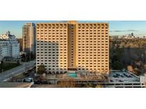 High-rise apartment building featuring an outdoor pool, parking, and views of the surrounding city skyline at 2479 Peachtree Ne Rd # 1714, Atlanta, GA 30305