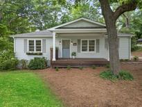 Charming bungalow with a welcoming front porch, light gray siding, and well-manicured lawn in a serene setting at 55 Cooper Lake Rd, Mableton, GA 30126