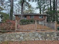 Charming brick home featuring mature trees and a stone retaining wall at 1917 Penelope Nw Rd, Atlanta, GA 30314