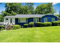 Charming blue home featuring a lush green lawn, manicured shrubs, and inviting front steps at 2011 Lexington Ave, Atlanta, GA 30344
