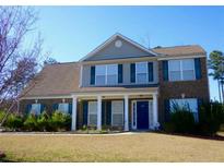 Charming two-story brick home featuring a manicured lawn, a welcoming front porch, and blue shutters at 8320 Mayfern Dr, Fairburn, GA 30213