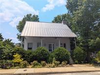 Charming cottage-style home with a metal roof and lush landscaping at 10540 Serenbe Ln, Chattahoochee Hills, GA 30268