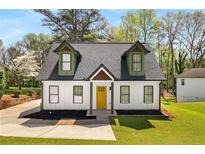 Charming home with a freshly manicured lawn and a bright yellow door at 1071 N Price Rd, Sugar Hill, GA 30518