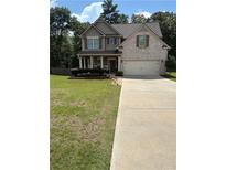 Charming two-story home with a manicured lawn, brick accents, and a welcoming front porch at 124 Gorham Gates Ct, Hiram, GA 30141