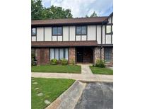 Inviting townhouse featuring a well-maintained lawn and charming brick accents at 1807 Ashborough Se Cir # B, Marietta, GA 30067
