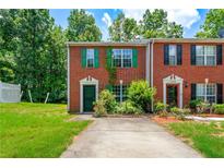 Charming brick townhouse featuring a well-manicured front lawn and colorful, contrasting shutters at 1382 Hollenbeck Ln, Riverdale, GA 30296