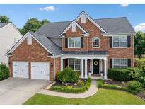 Charming two-story brick home with a well-manicured front yard and two car garage at 3850 Calomel Dr, Cumming, GA 30040