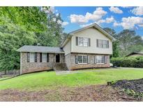 Charming two-story home with a well-maintained lawn and brick and siding exterior at 4444 Lisa Nw Way, Lilburn, GA 30047