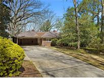 Charming single-story brick home featuring a spacious driveway and mature landscaping at 2386 Bohler Nw Rd, Atlanta, GA 30327
